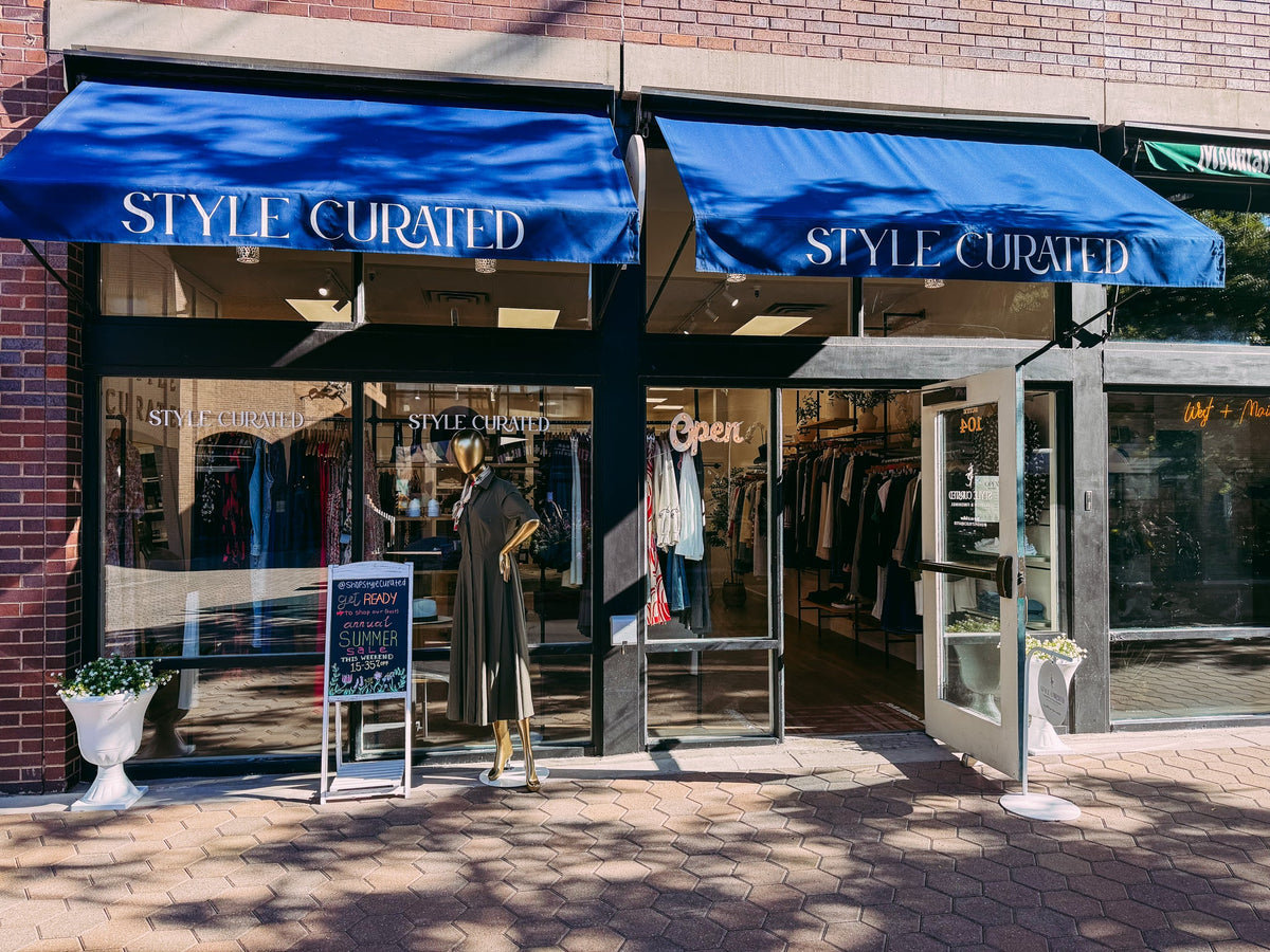 The Style Curated storefront with navy awnings in Old Town Square, Fort Collins